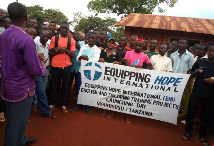 Equipping Hope Intl in Nyarugusu Refugee Camp, Tanzania. Students ready to learn with Equipping Hope sign.