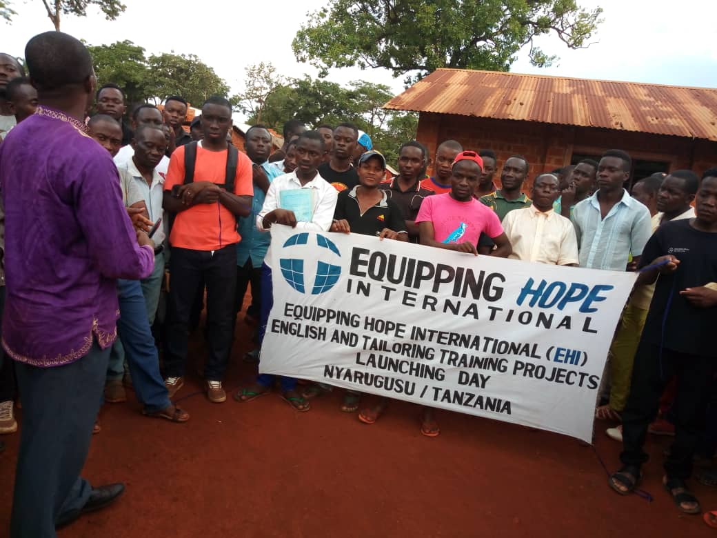Equipping Hope Intl in Nyarugusu Refugee Camp, Tanzania. Students ready to learn with Equipping Hope sign.