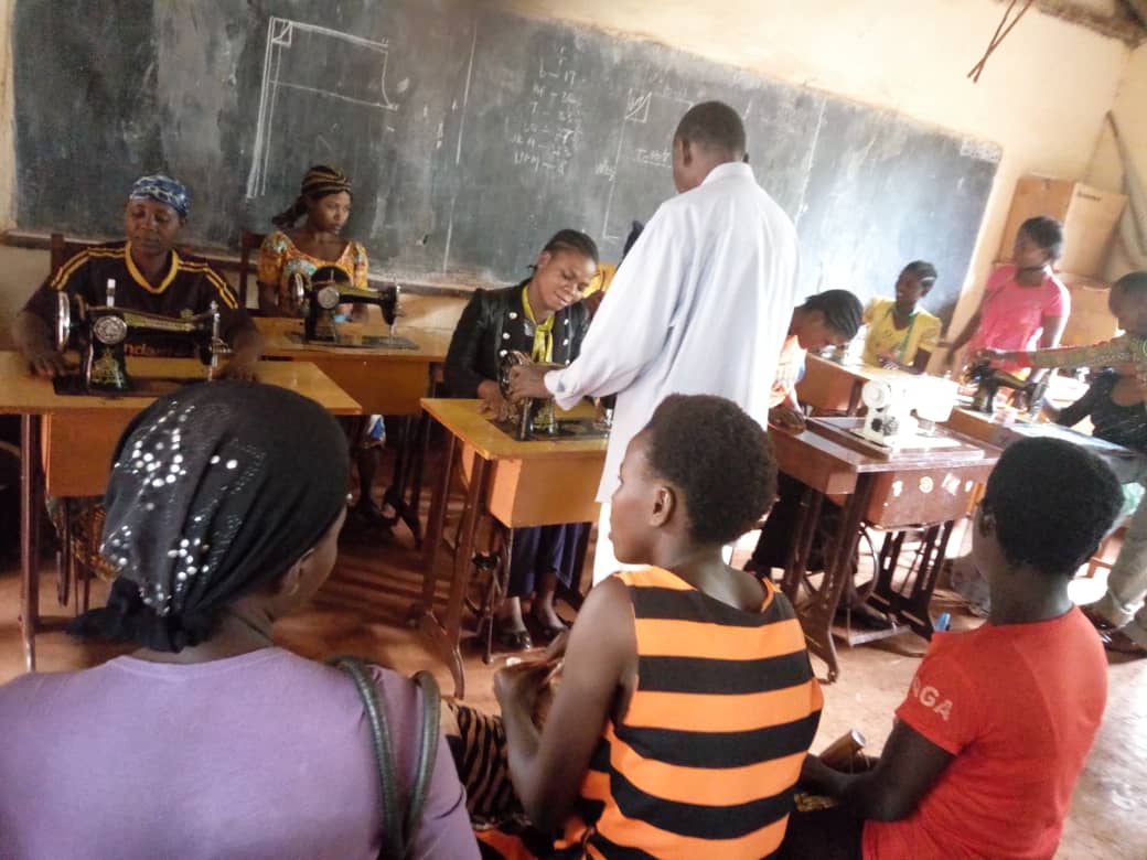 Tailoring apprentices and master tailors working together on sewing machines at Nyarugusu Refugee Camp in Tanzania. The apprenticeships are a part of Equipping Hope Interanational's Business of Hope program.